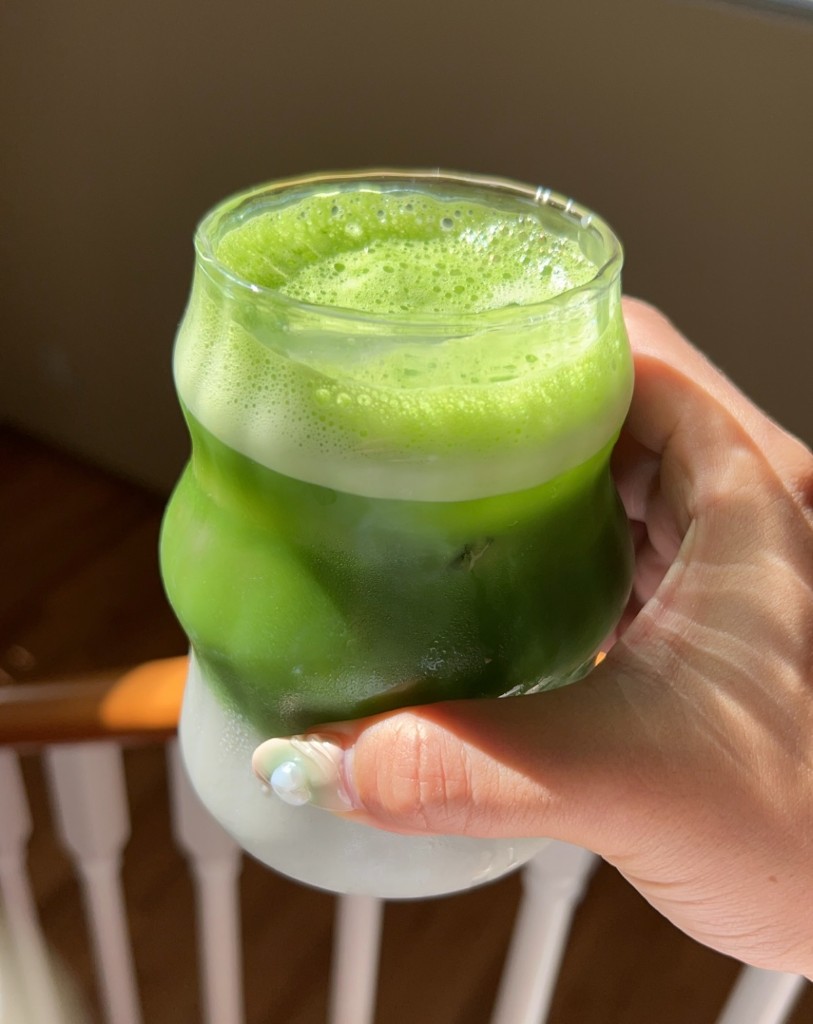 Iced matcha latte in a wavy glass.